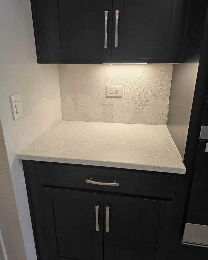 Wall between dark upper cabinets before the job, painted and bare