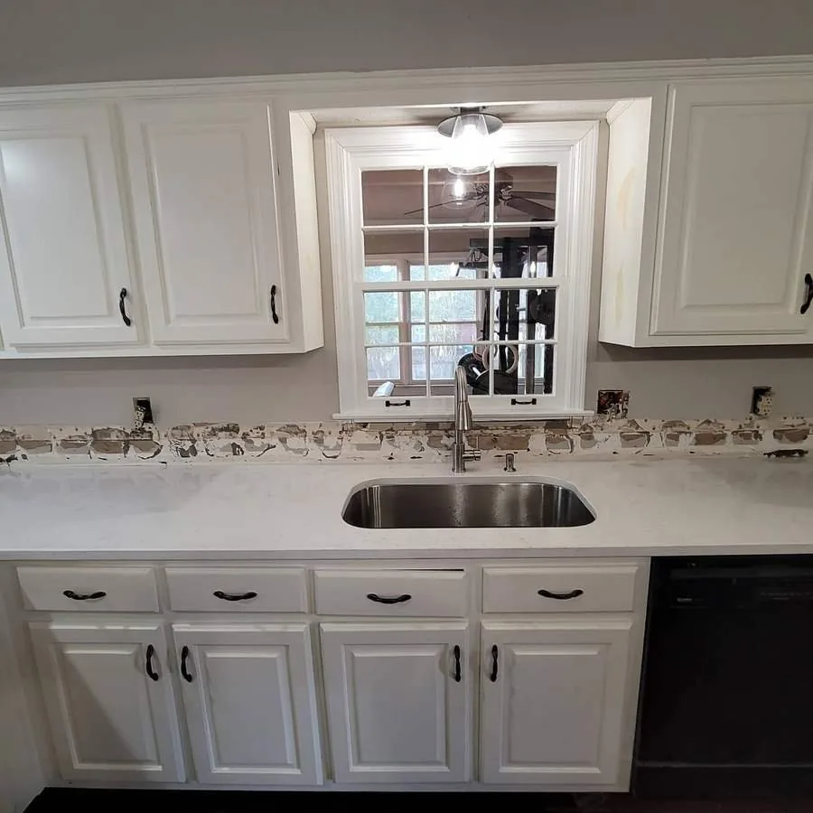 Kitchen wall before the job: bare drywall above the counter with the outlets exposed