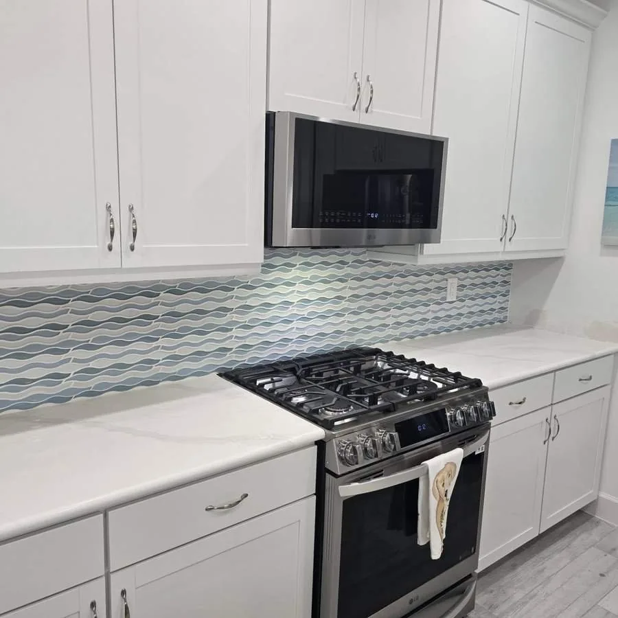Kitchen in Palm Coast with a blue wave-pattern mosaic backsplash running behind the range